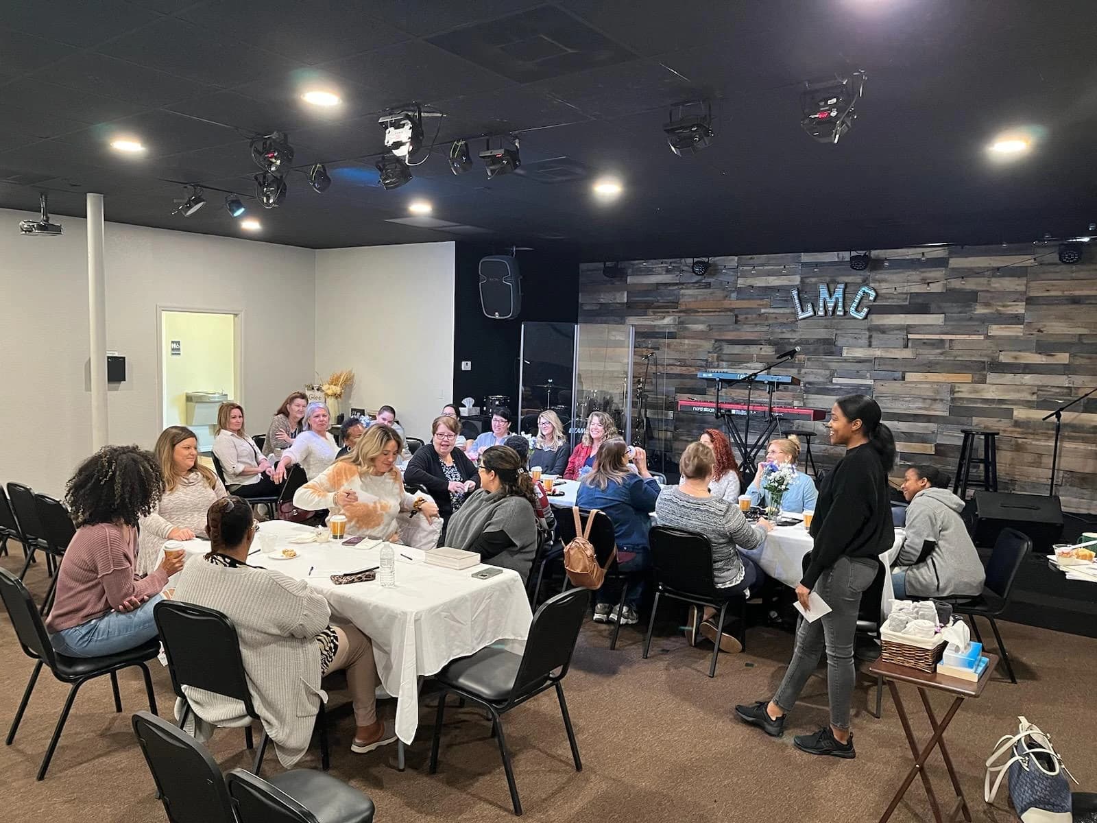 People sharing conversation around tables at Living Message Church.