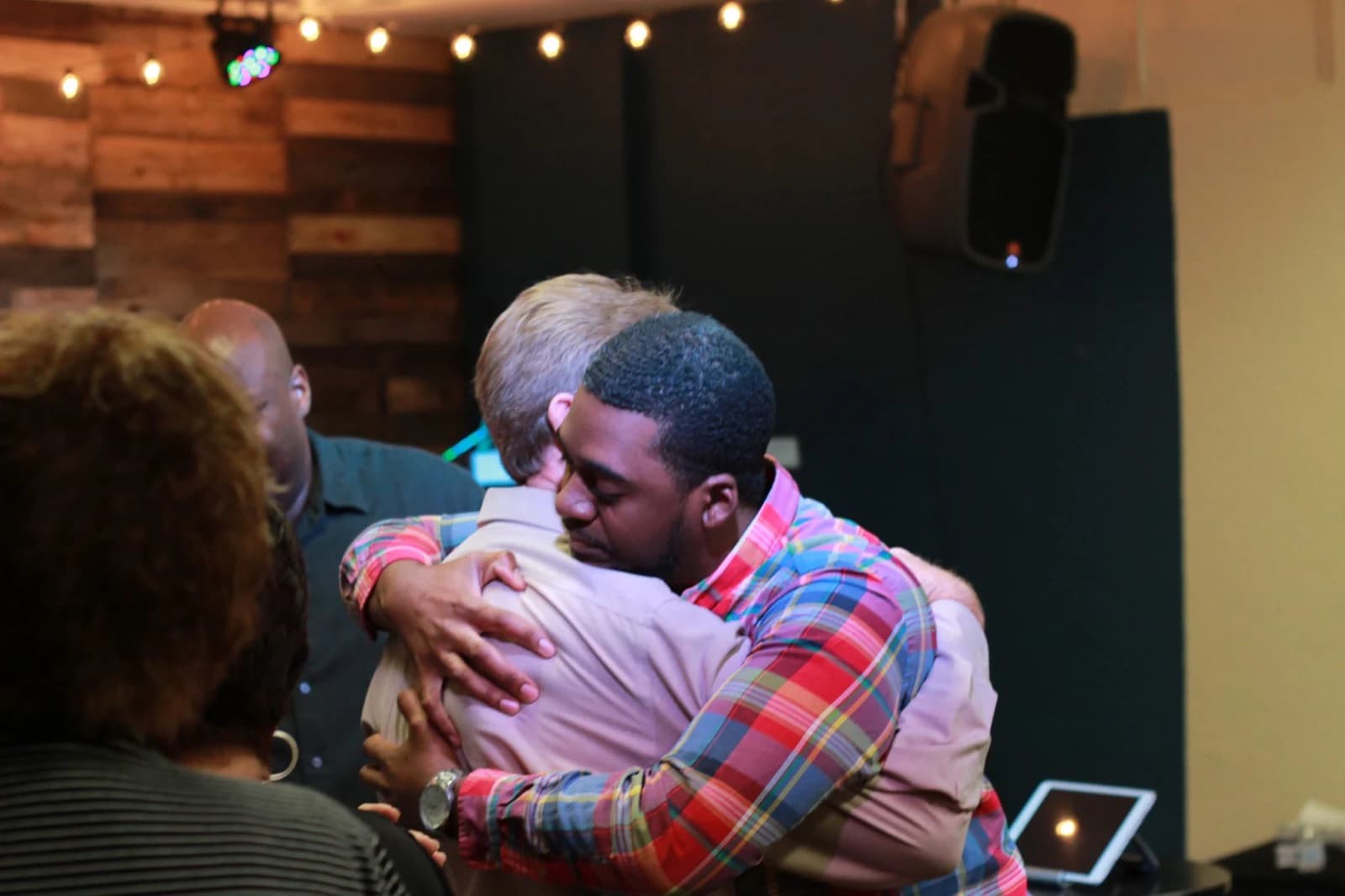 Two people embracing at a Living Message Church gathering.